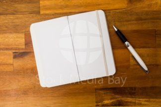notebook and pen on table office - stockphoto
