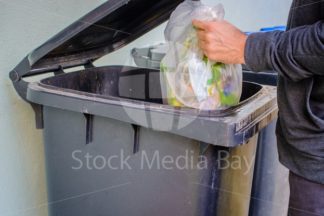 men putting trash in can at home - Stock Media Bay